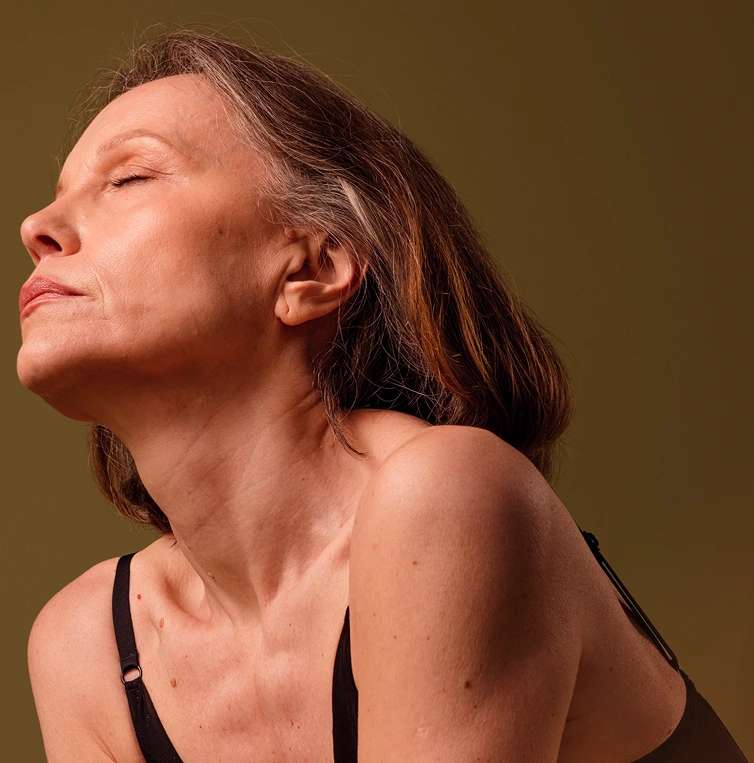 Woman in profile with eyes closed against neutral background